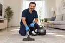 Zemini temizlik ekipmanıyla temizleyen görevli